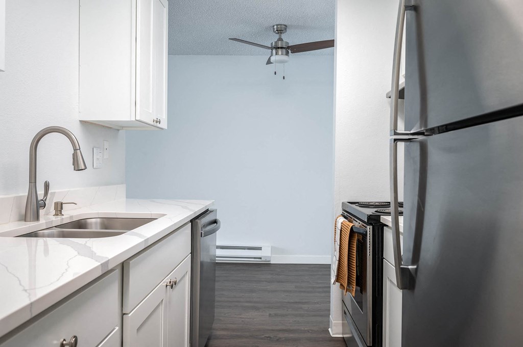 a kitchen with white cabinets and stainless steel appliances